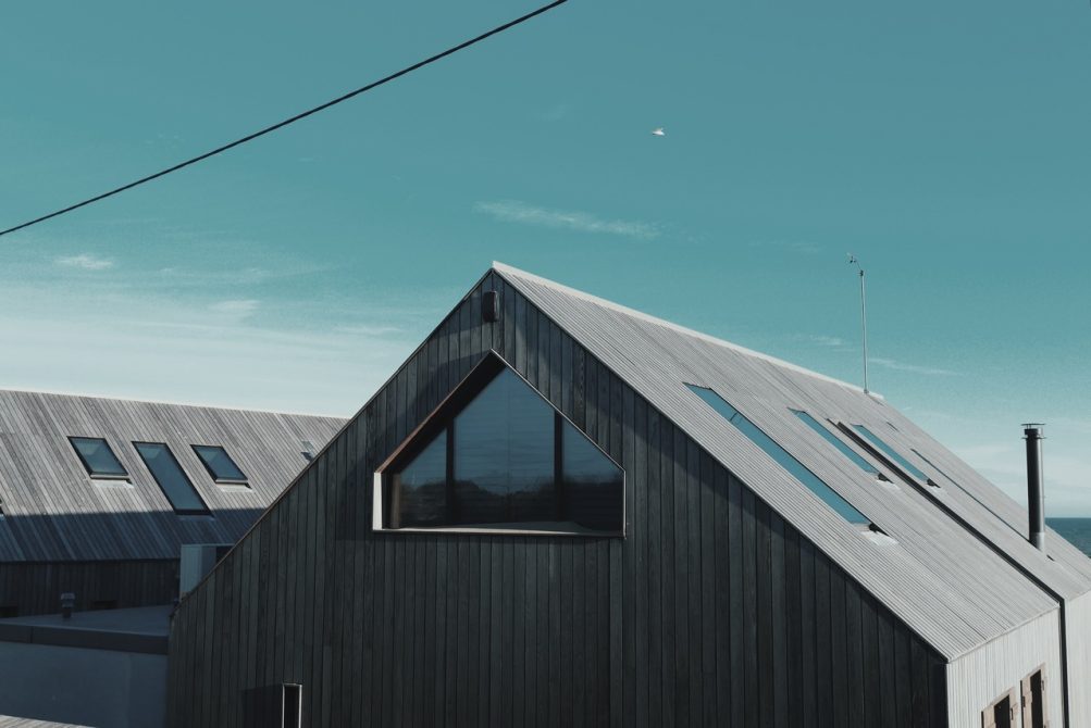 szary drewniany dom w nowoczesnym stylu z oknami w dachu