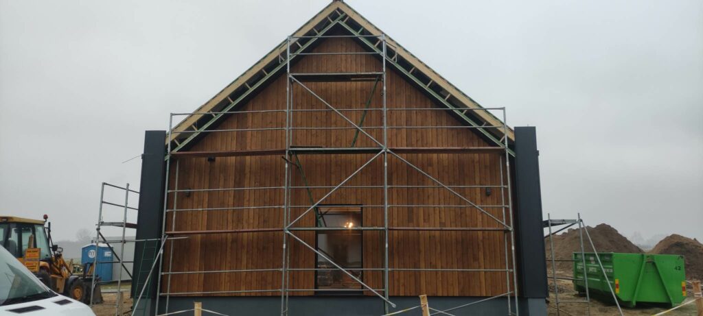 dom modułowy z dachem dwuspadowym i elewacją z blachy na rąbek oraz elewacji drewnianej na ścianie szczytowej